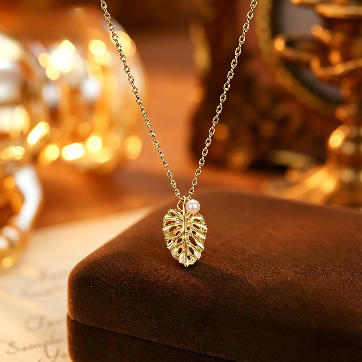 Brushed leaf pendant necklace styled on brown velvet
