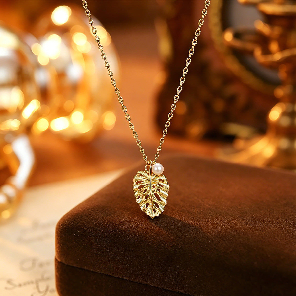 Brushed leaf pendant necklace in warm ambient light
