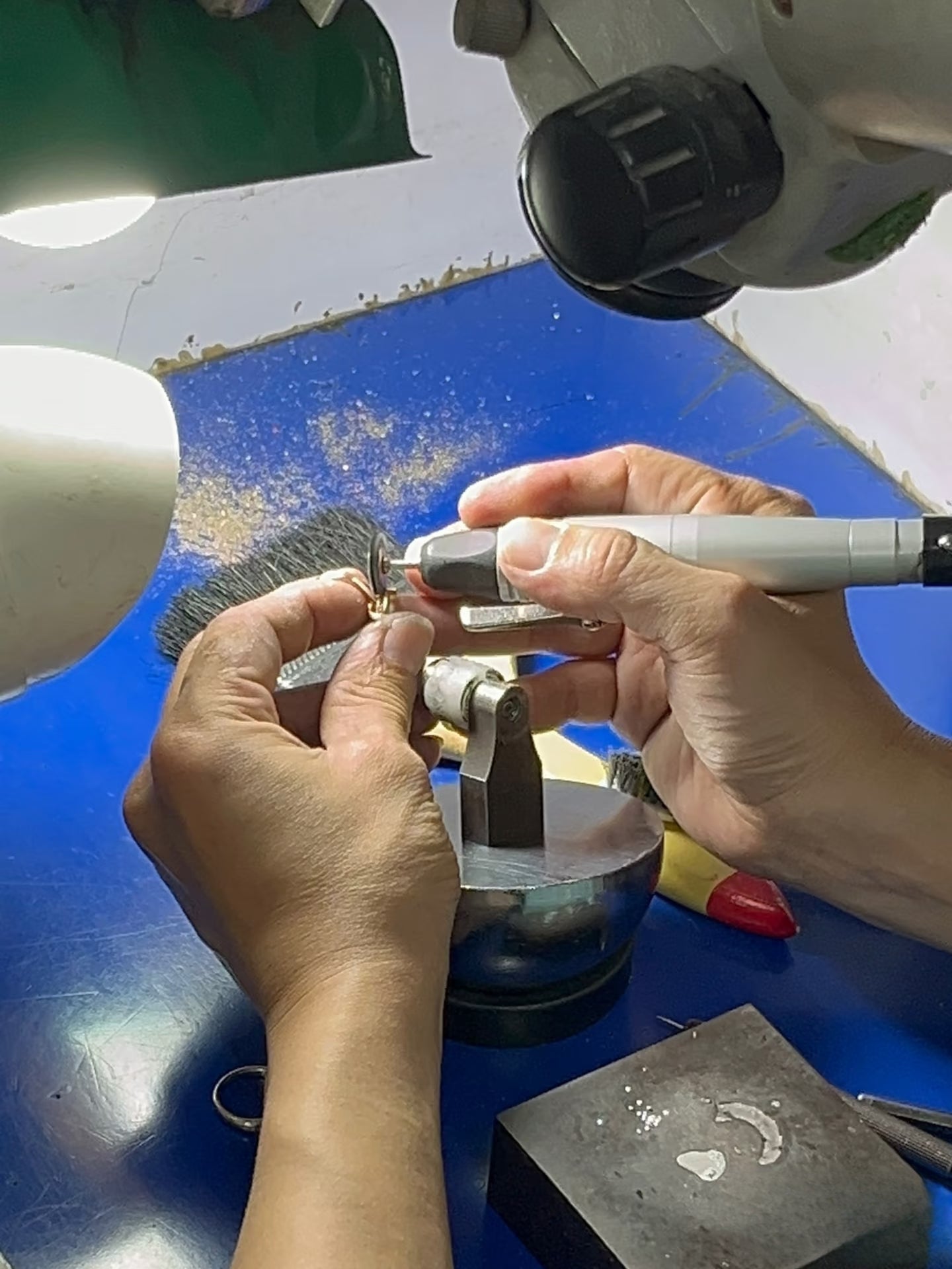 A jeweler carrying out precision finishing under magnification